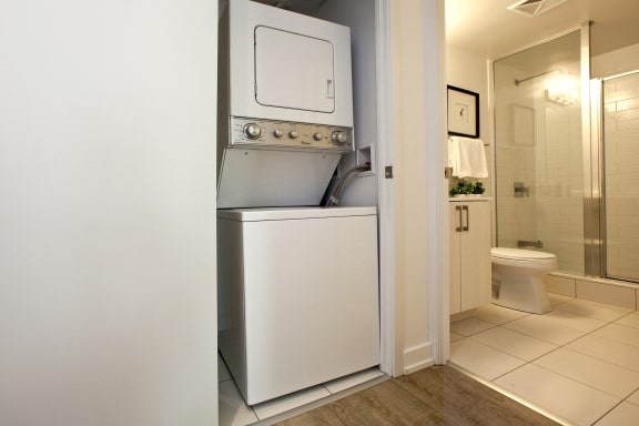 a laundry room with a washer and dryer next to a bathroom
