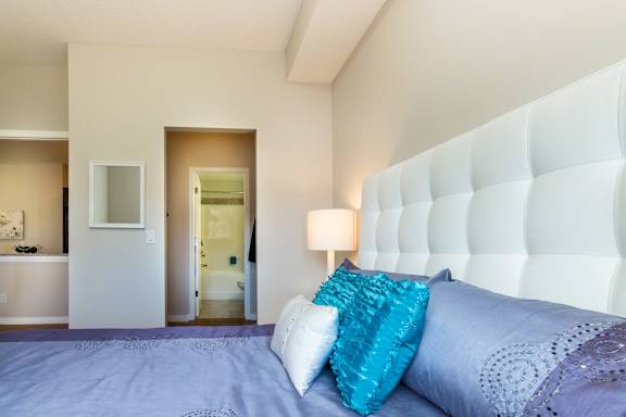 a large bed with blue pillows in a hotel room