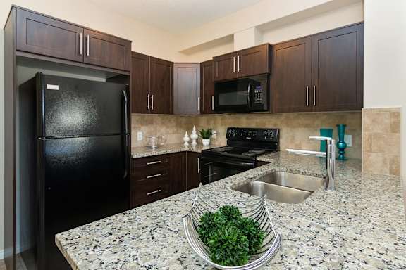 a kitchen with granite counter tops and black appliances