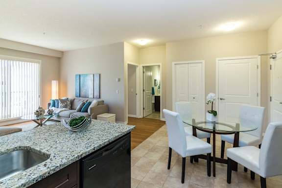 a living room and dining room with a table and chairs