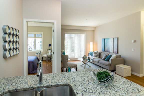a living room and kitchen with a couch and a table