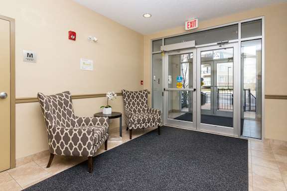 a lobby with two chairs and an exit door