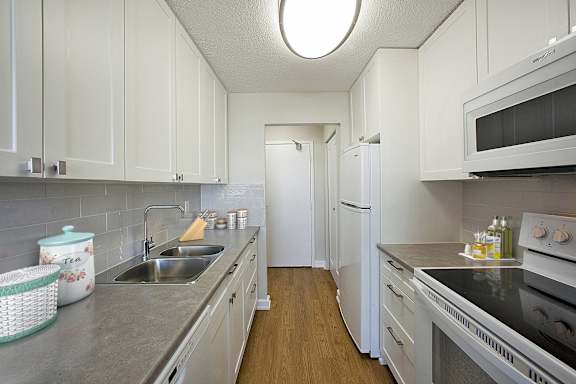 a kitchen with white cabinets and stainless steel counter tops and a sink