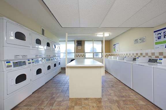 a laundry room with washers and dryers and a counter