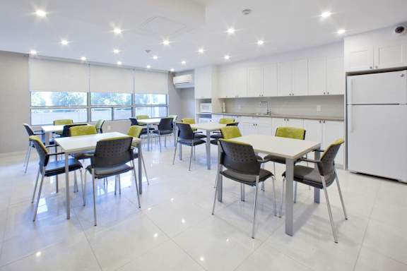 a large dining room with tables and chairs and a kitchen