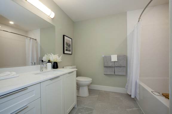 A white bathroom with a toilet, sink, and tub.