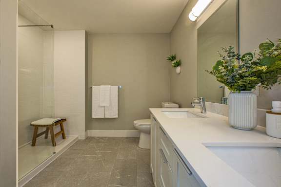 A bathroom with a white counter and a toilet.