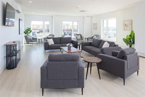 A living room with grey couches and a wooden floor.