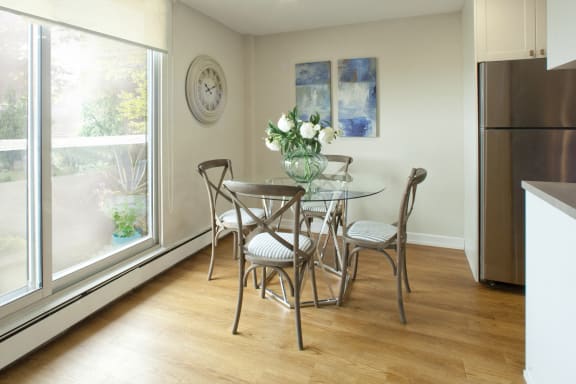 a dining room with a table and chairs and a large window