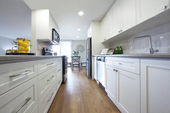 a large white kitchen with white cabinets and stainless steel appliances