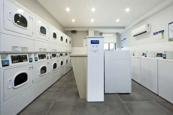 A row of washing machines in a laundromat.