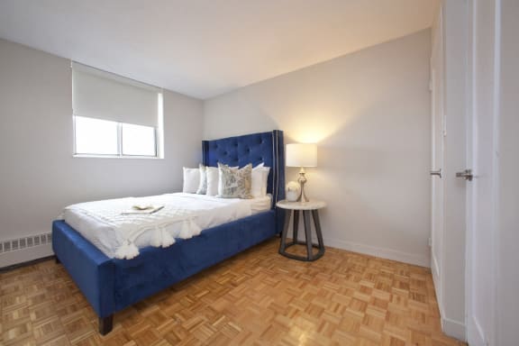 a bedroom with a blue bed and a wooden floor