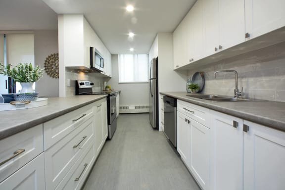 a large kitchen with white cabinets and stainless steel appliances
