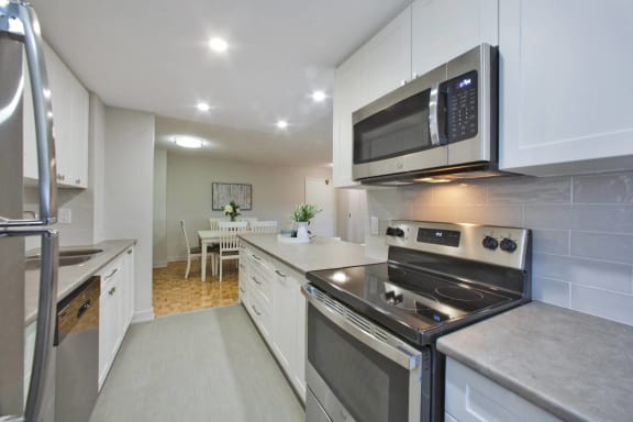 a kitchen with stainless steel appliances and white cabinets