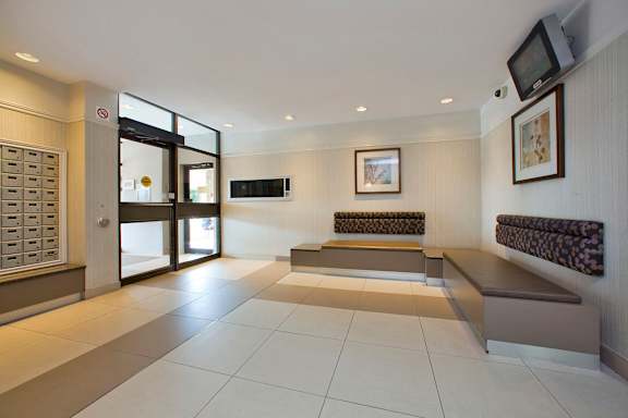 A room with a bench and a television mounted on the wall.