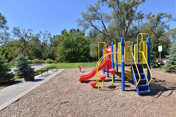 a playground at a park with slides and a bench