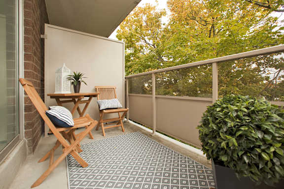A small balcony with a table and chairs.