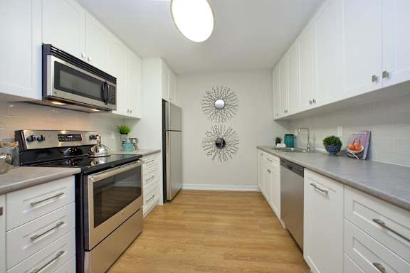 A kitchen with white cabinets and a black stove top oven.