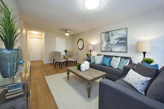A living room with a grey couch and a wooden coffee table.
