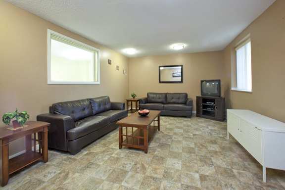 A living room with a grey couch, a brown coffee table, and a white cabinet.