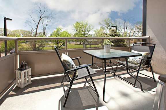A table and chairs are set up on a balcony.