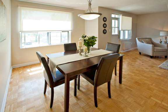 A dining room with a table and chairs.