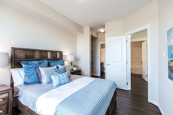 a bedroom with a large bed and a door to a bathroom