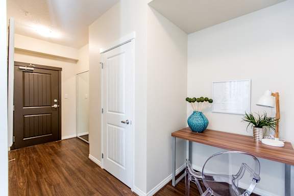 a corridor with a desk and a chair and a door to a bedroom