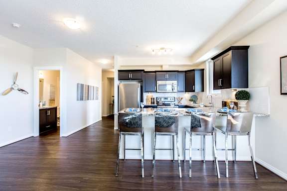 an open kitchen and living room with a bar and stools
