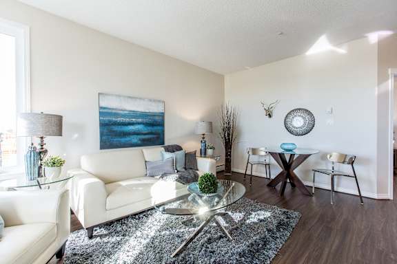 a living room with white furniture and a glass coffee table