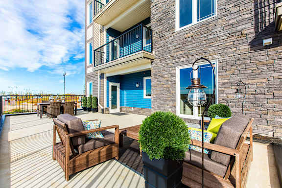 the deck of a house with chairs and a table