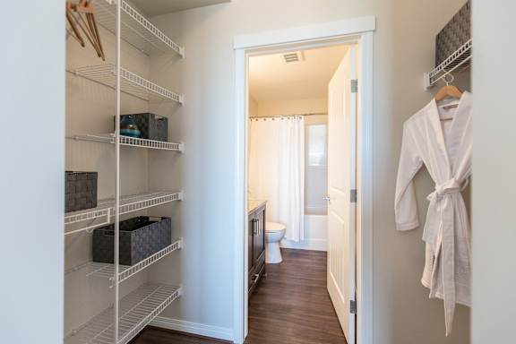 a walk in closet with a door to a bathroom