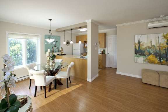 A modern dining room with a glass table and chairs.