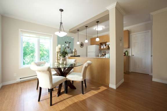 A dining room with a glass table and chairs.