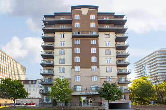 A large apartment building with balconies on the upper floors.