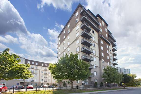 A tall apartment building with balconies on the upper floors.