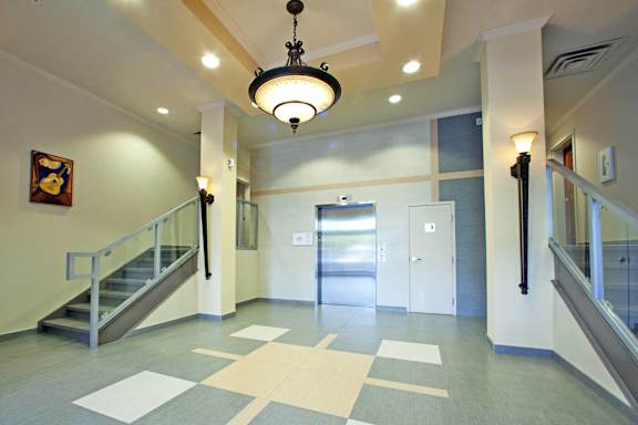 A hallway with a staircase and a chandelier.