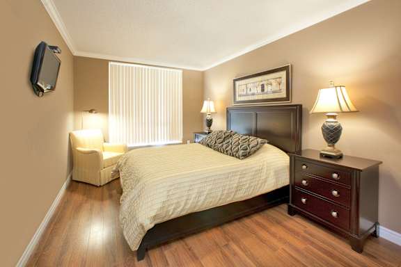 A bedroom with a bed, nightstand, and two lamps.