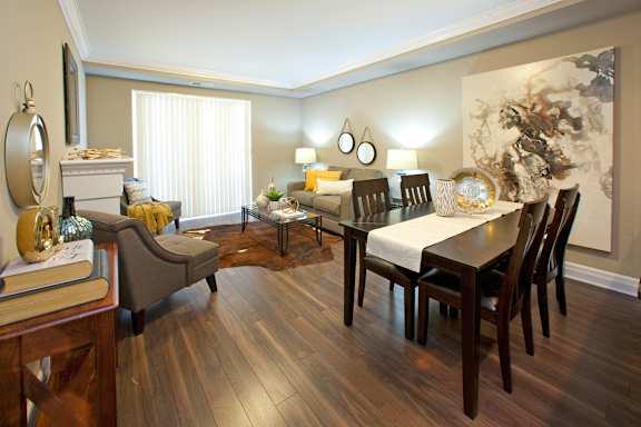 A living room with a fireplace, chairs, and a dining table.