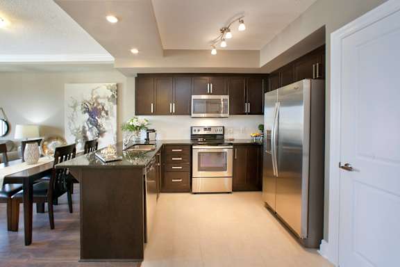 A modern kitchen with dark brown cabinets and a wooden island.