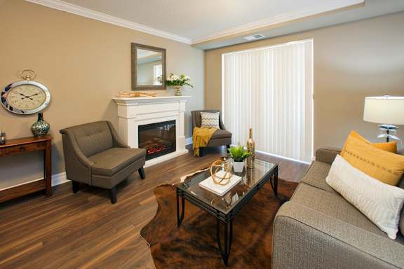 A living room with a grey couch, a fireplace, and a coffee table.