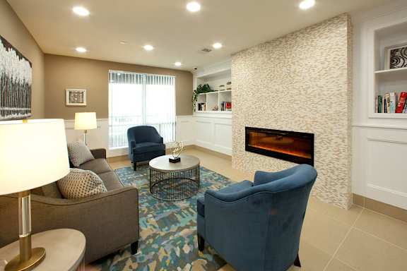 A living room with a fireplace and a blue chair.