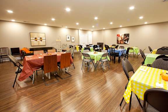 A room with tables and chairs set up for a gathering.