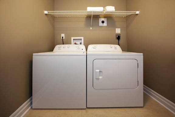 Two white washing machines in a laundry room.