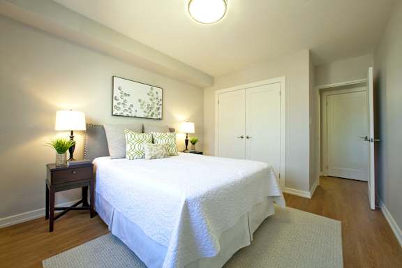 A bedroom with a bed, nightstand, and two lamps.