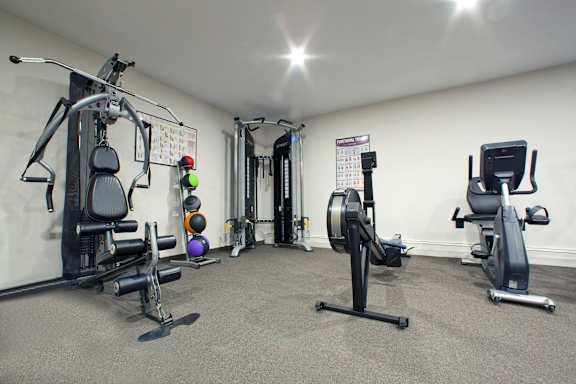 A well-equipped gym with various exercise machines and weights.