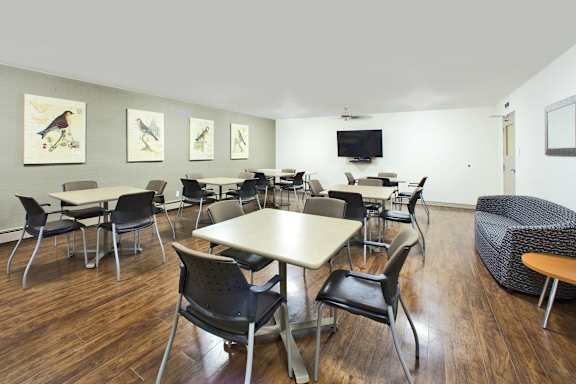 A conference room with a long table surrounded by chairs.