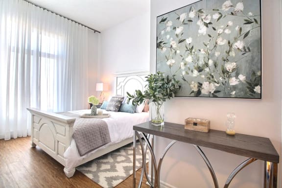 a bedroom with a bed and a painting on the wall