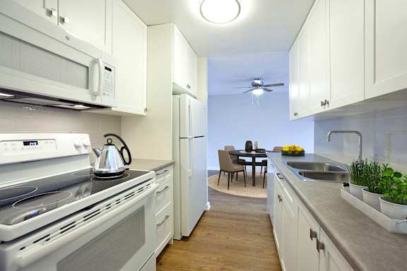 A modern kitchen with white cabinets and stainless steel appliances.