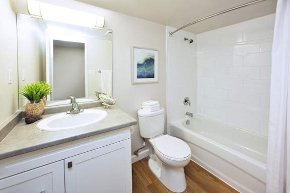 A white bathroom with a toilet, sink, and bathtub.